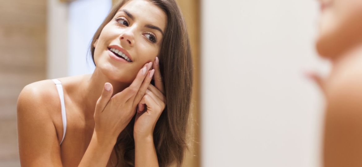 Woman removing pimple from her face