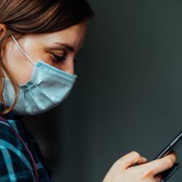 Portrait of adult female with mobile phone in her hands.