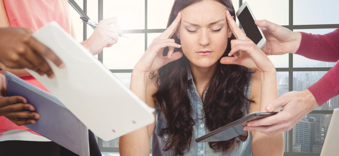 Stressed woman sitting with hands on forehead